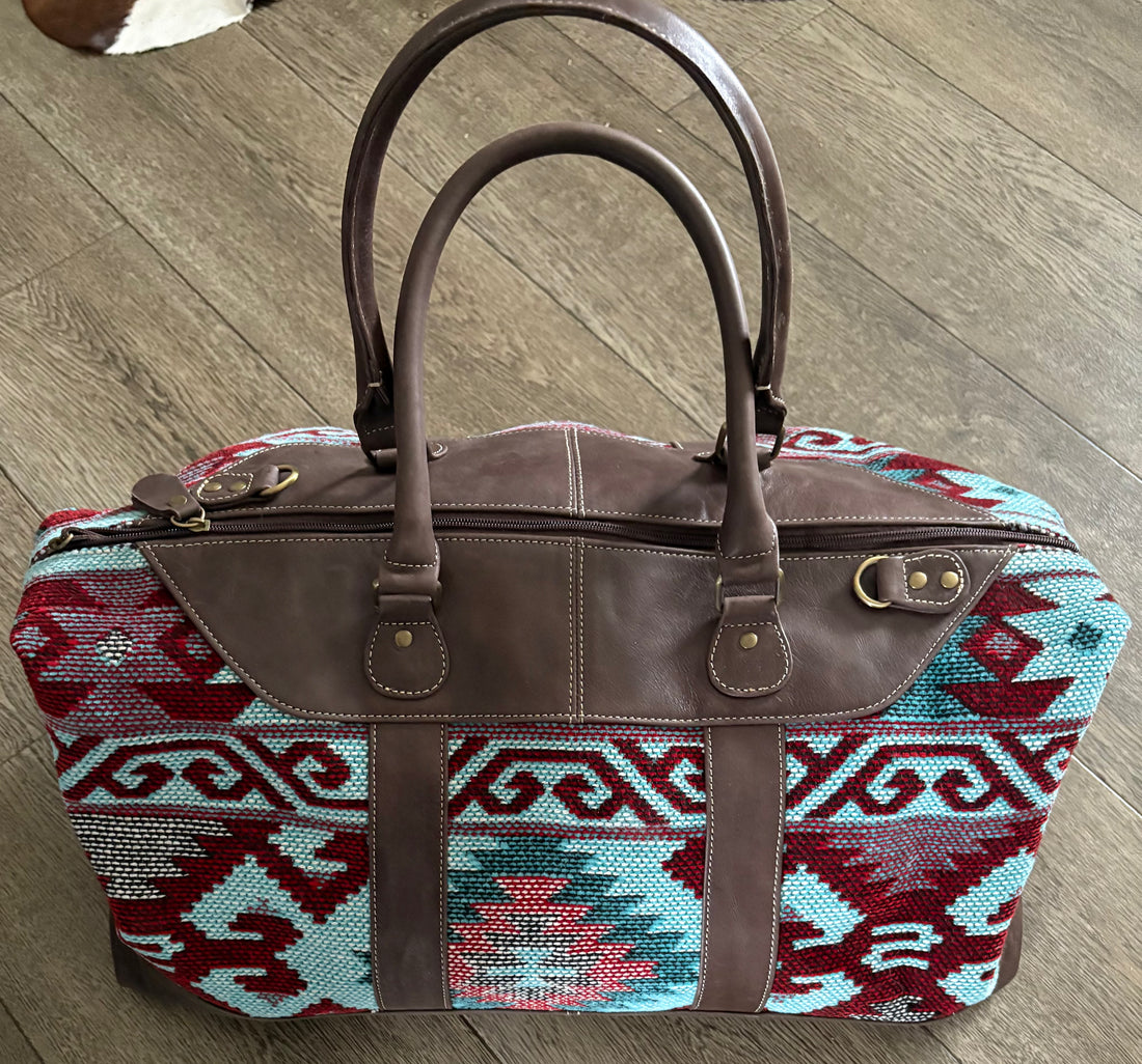 A meticulously hand weaved wool saddle blanket and Leather Duffle Bag